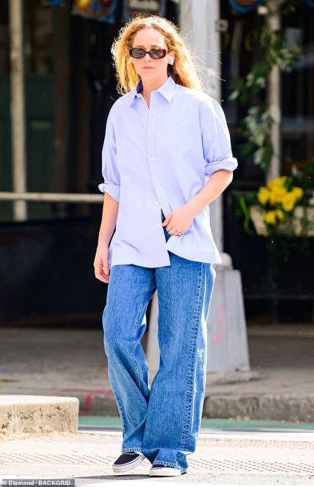 Jennifer Lawrence opts for a casual look in loose-fitting jeans and an oversized men’s shirt while running errands in New York City.